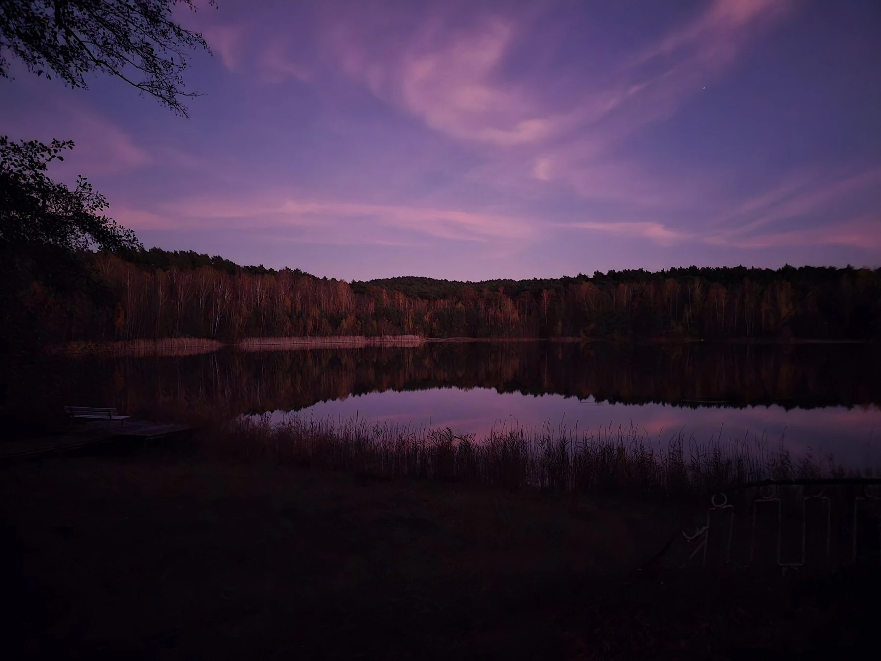 Der See in tiefem Violett kurz nach Sonnenuntergang, kleiner Steg am Ufer