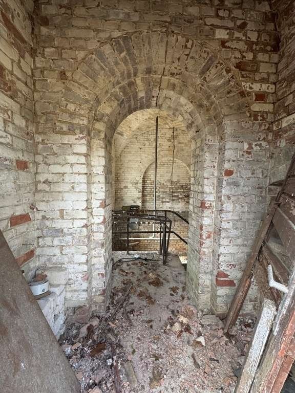 Innenansicht des Wasserturms: Blick durch einen Ziegel-Rundbogen auf eine zweite Bogenöffnung